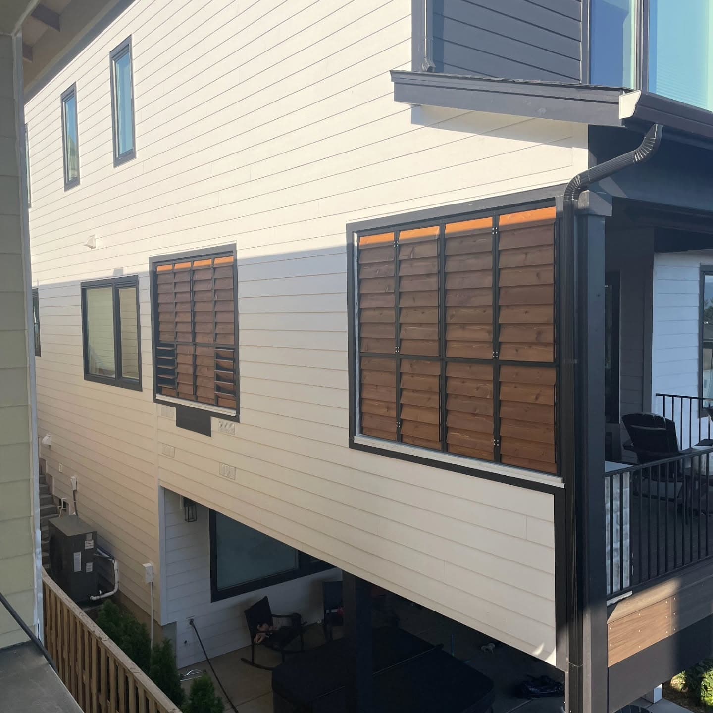 Exterior home facade with cedar louvered shutters framing windows