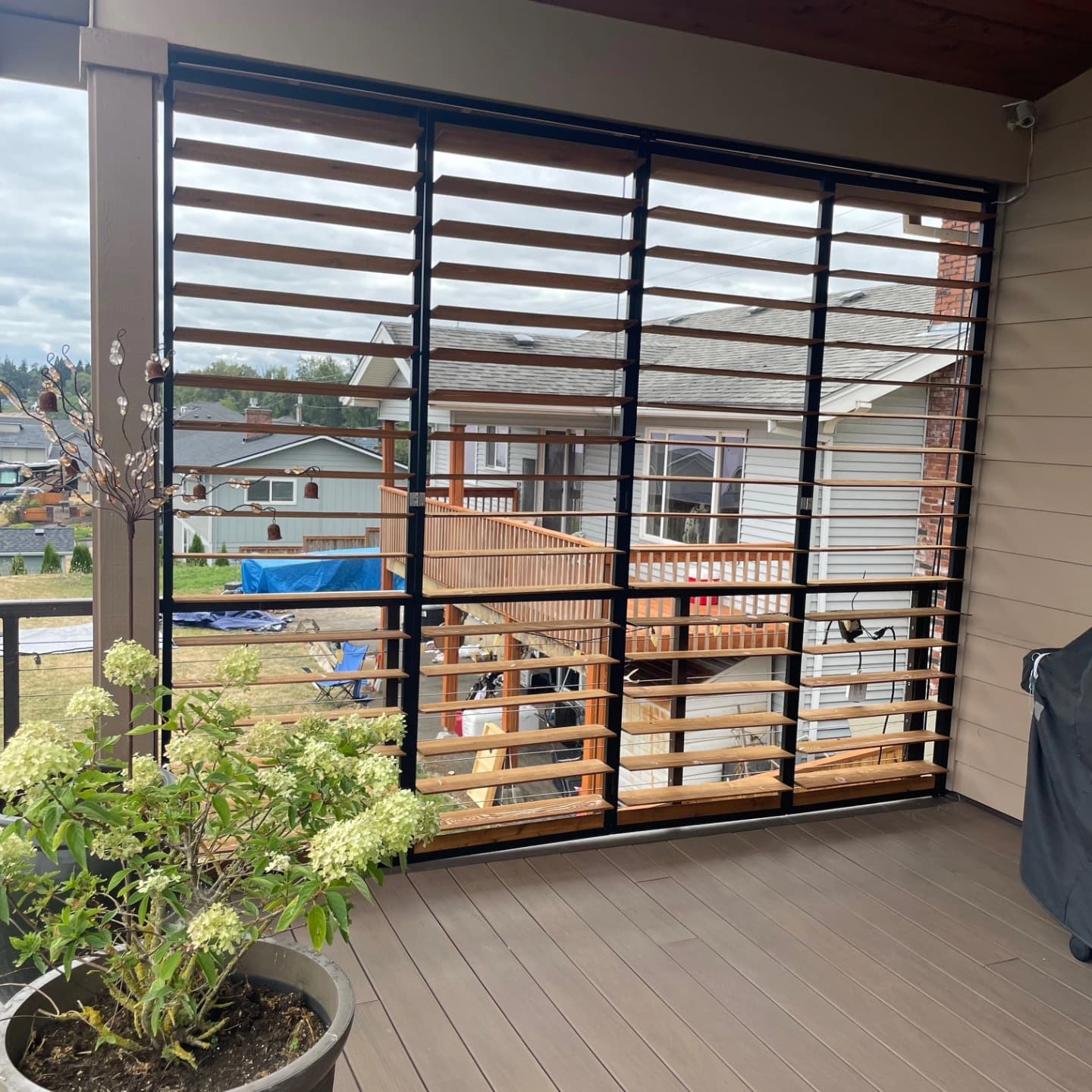 Cedar louvered screen panel on a second-story deck with garden view