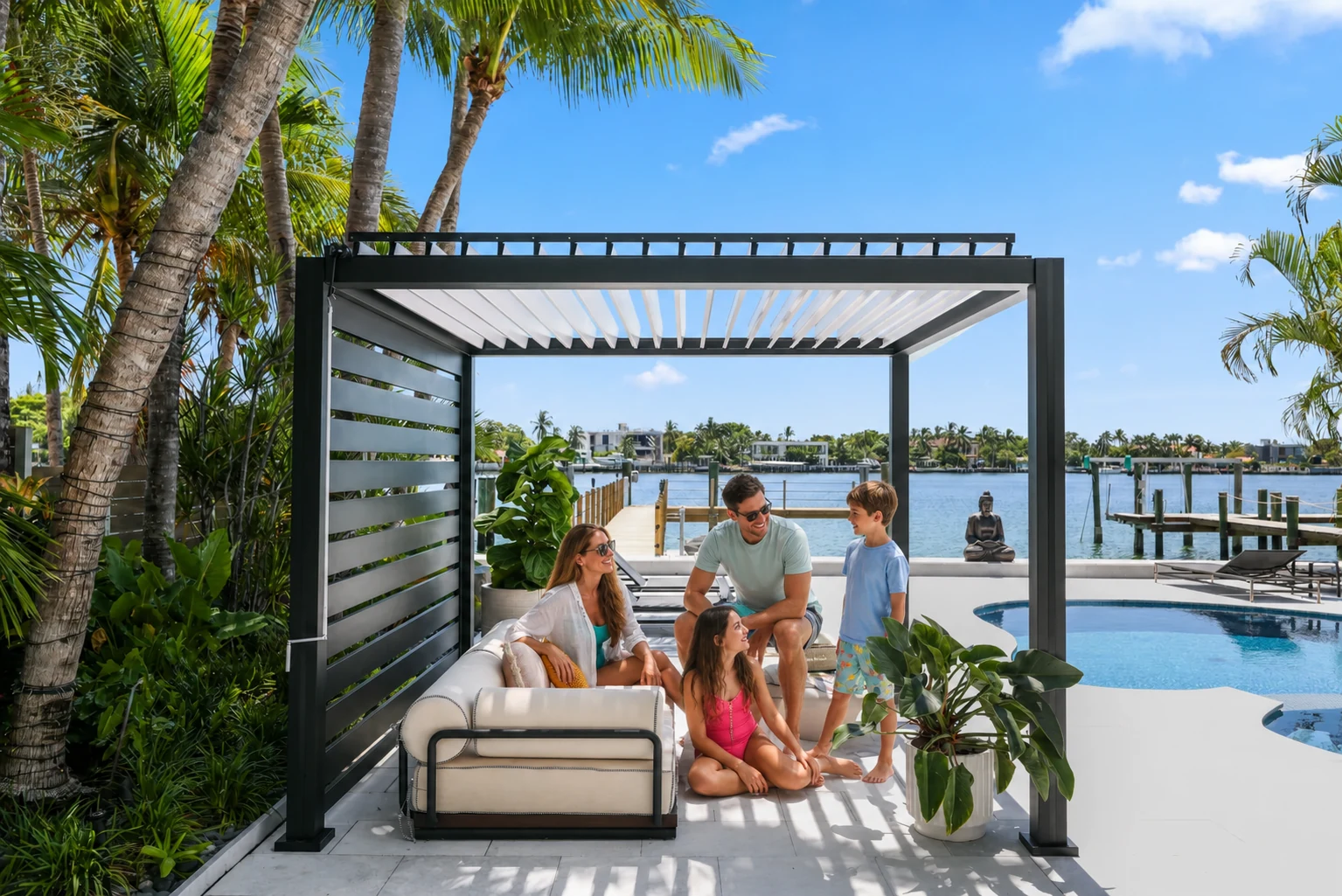 Family relaxing beneath a black Azenco K-BANA cabana with white manual louvers